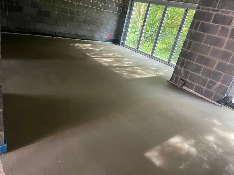 Finished screed in an extension with brick and blockwork walls and garden doors