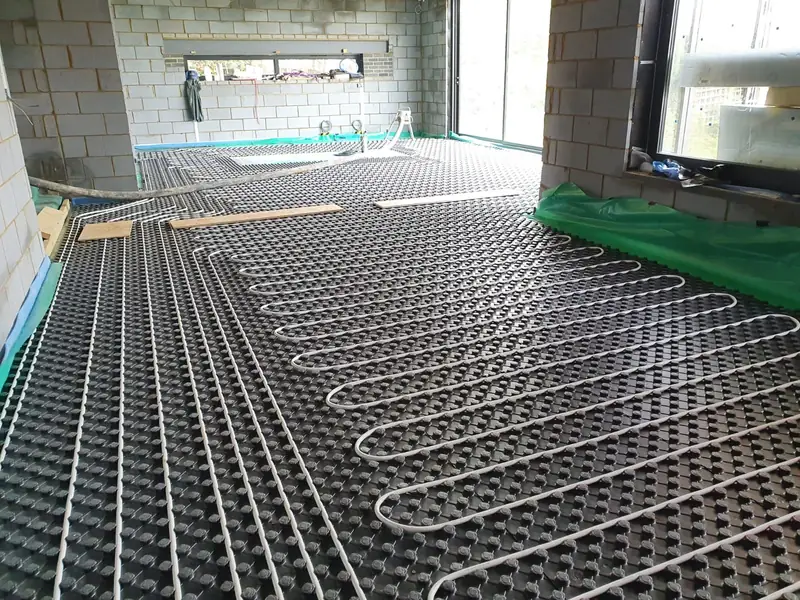 Underfloor heating pipe loops on castellated panels in a large room awaiting screed